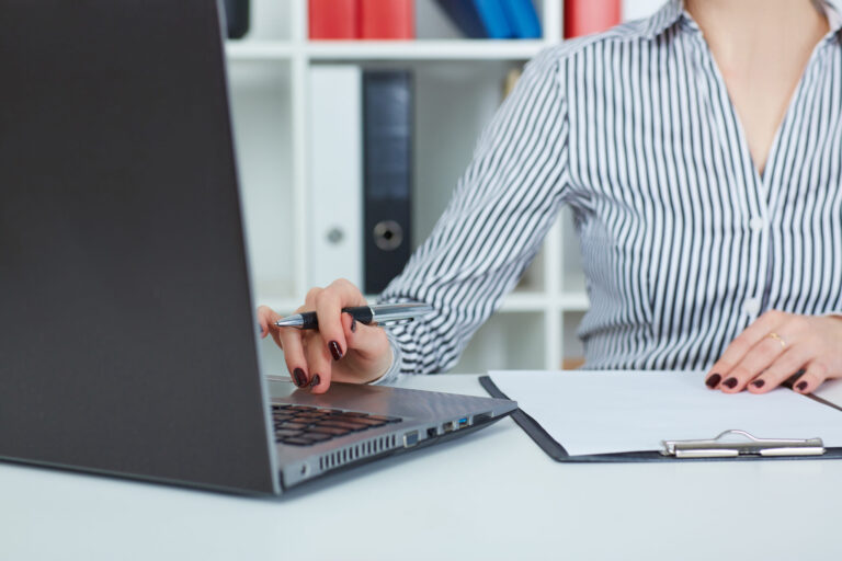 Close up of female hands typing on laptop keyboard.
